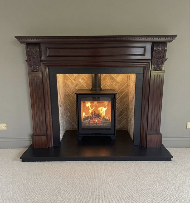 A Contura 210 wood burning stove in a herringbone brick chamber with a restored mahogany surround in Pannal, Harrogate