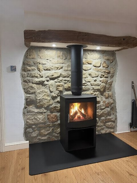 A Dik Geurts Ivar 8 wood burning stove against a stone cottage wall with a black twin-wall flue near Ripon