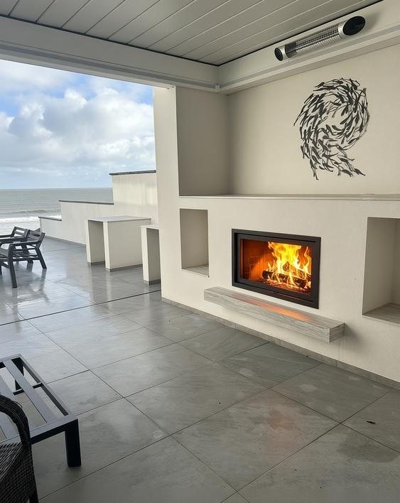 Dik Geurts Instyle 1000 wood burning fire lit in the covered outdoor area of an Art Deco home at Filey