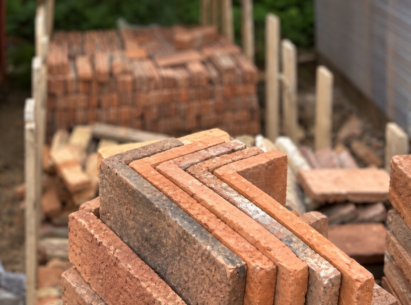 Reclaimed bricks cut into L-shaped pistol corners to wrap around a fireplace chamber