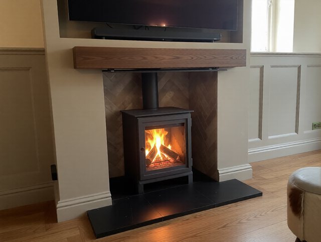 The finished feature chimney breast in Thirsk, with a Dik Geurts Soren 5, herringbone brick chamber, oak beam and recessed television