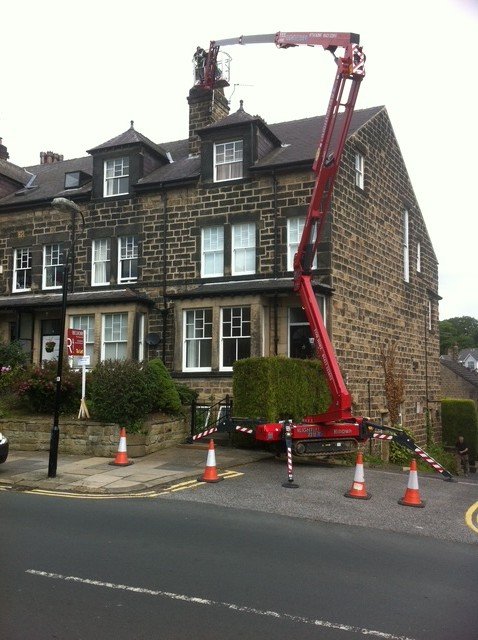 A tall Harrogate chimney stack reached by boom lift to install a stainless steel liner.