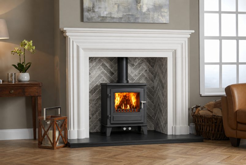 Urban Graphite Slate Grey porcelain brick stove chamber shown with a Broadway Scala limestone surround and Clock Blithfield 5 multi-fuel stove
