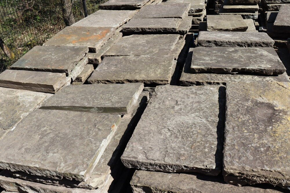 A selection of reclaimed Yorkstone flags awaiting inspection before milling