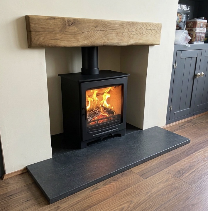 Natural oak beam fascia above a stove, slate hearth and Glasroc chamber