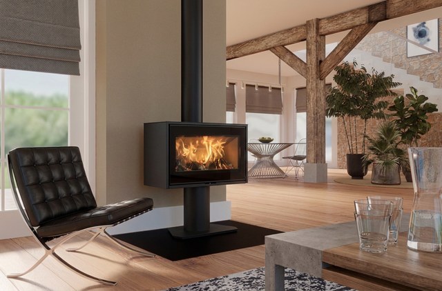 Heta Scan-Line 100 wood burning stove on its pedestal in an open-plan room with exposed timber trusses